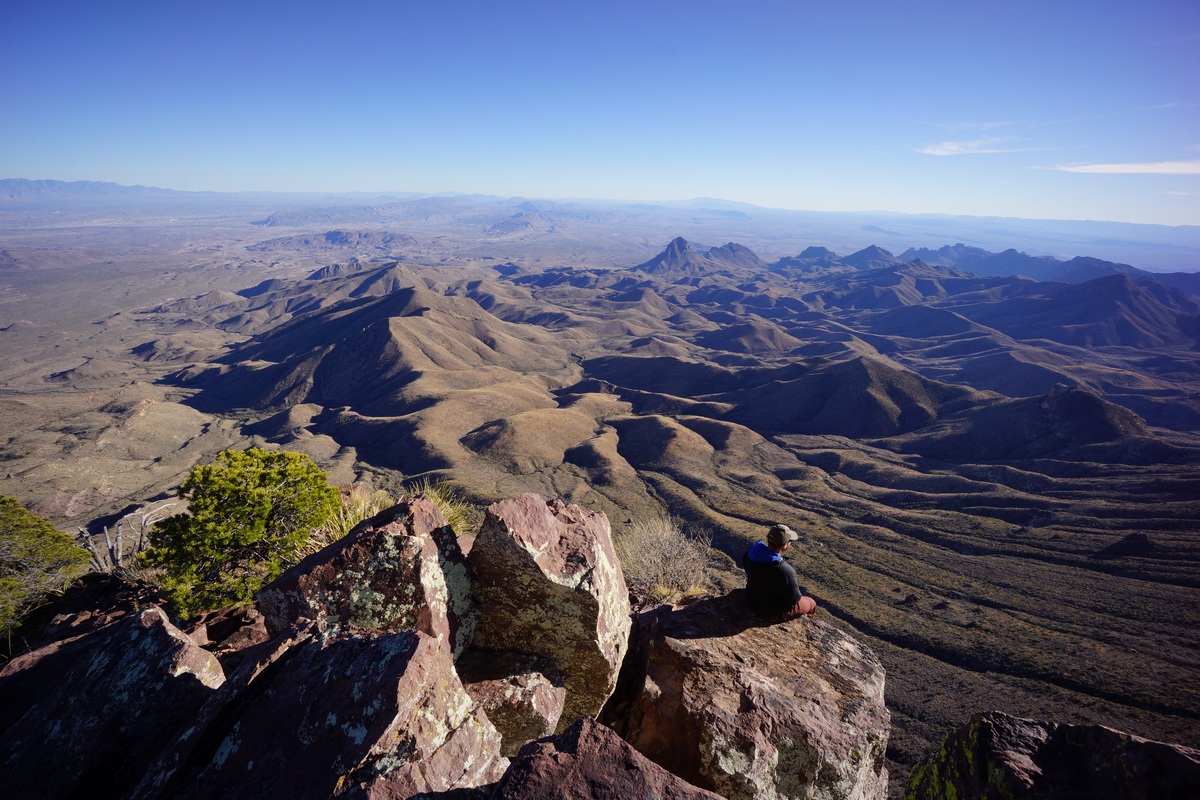 sitting on the edge of a boulder on the south rim
