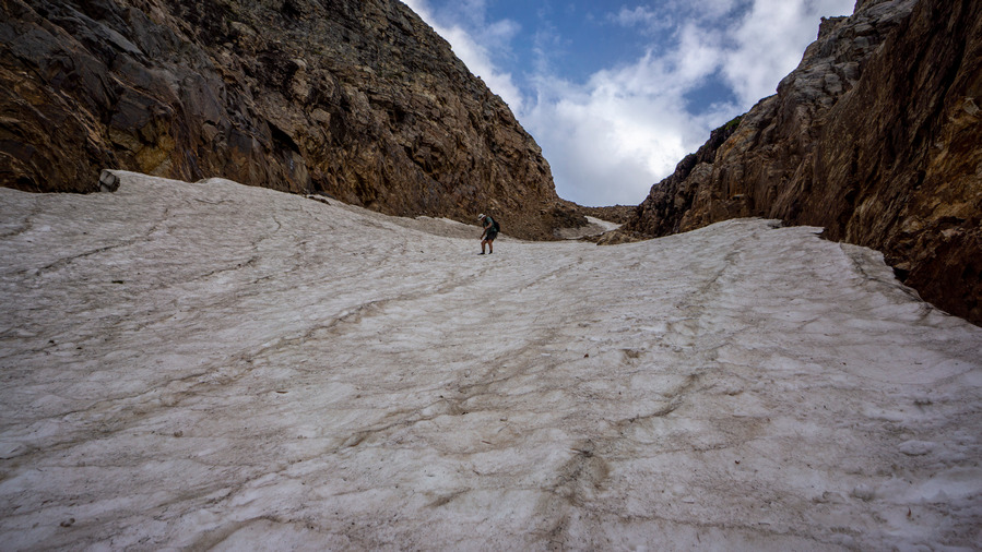 hiker descending steep snow chute in ruby mountains nevada