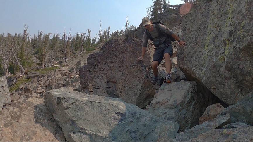 hiker climbing over boulders along mountainside in hells canyon idaho