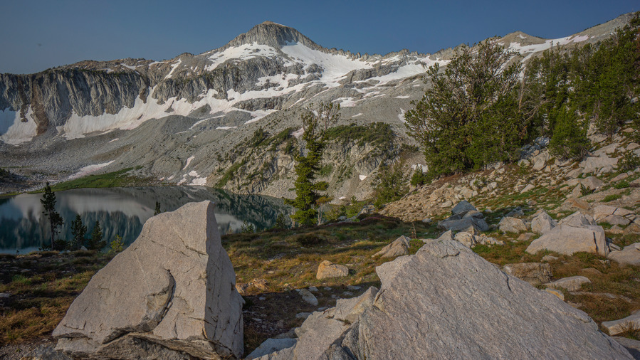 view of glacier peak with alrge boulders in foreground and glacier lake