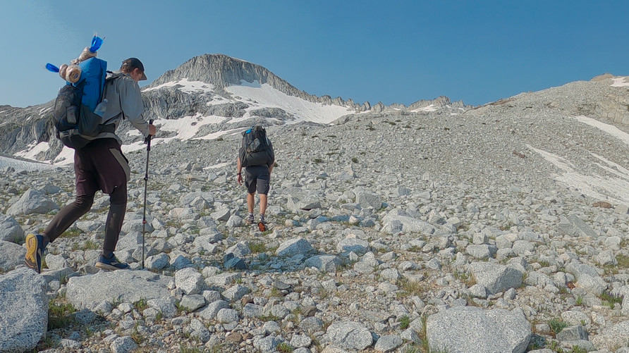 two hikers below wallowa mountains crest on summit hike to eagle cap peak