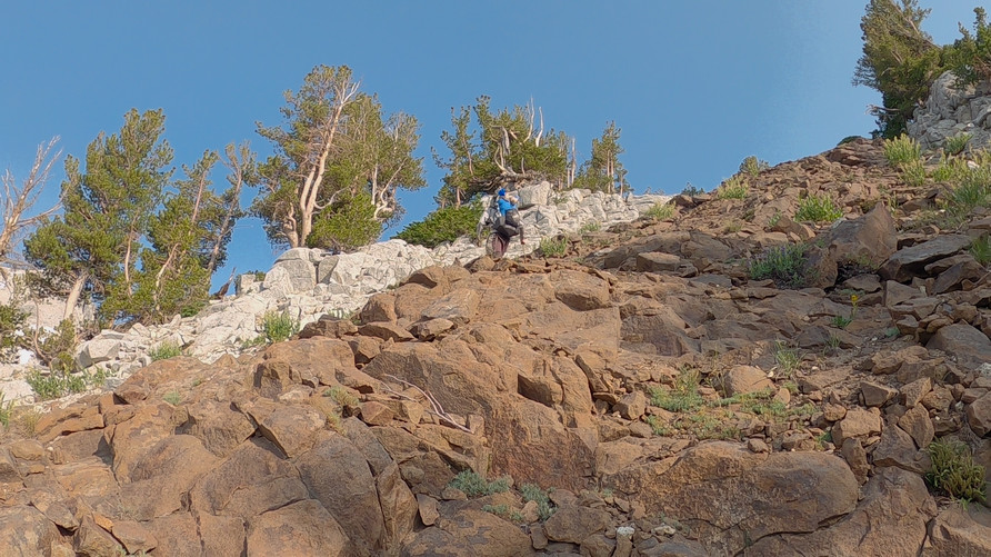 hiker climbs boulder field in wallowa mountains